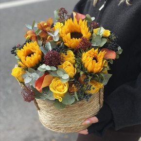 Композиция в сумке "Тональность" из подсолнухов, калл, ягод вибирнума, лимонных роз, скиммии и орхидеи в Клину